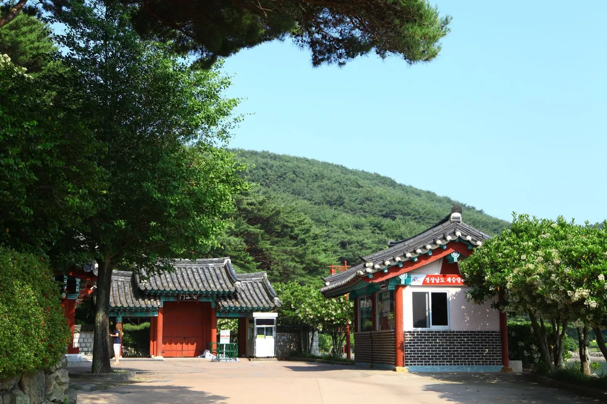 숲을 배경으로 선 단청한 문과 건물들