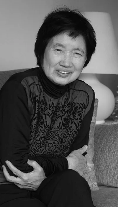 짧은 머리의 노년 여성이 미소 짓는 흑백 사진