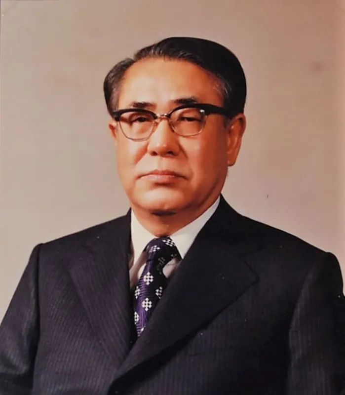 안경을 쓰고 양복을 입은 노년 남성의 컬러 공식 초상