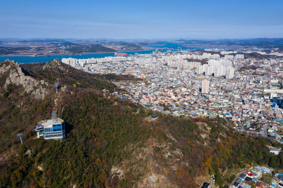산 위 케이블카 너머로 내려다보이는 바닷가 도시
