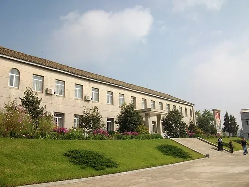 잔디밭 너머로 길게 이어진 여러 층짜리 건물 외관