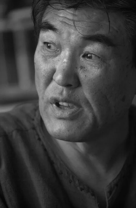 주름진 얼굴의 노년 남자를 가까이 찍은 흑백 사진