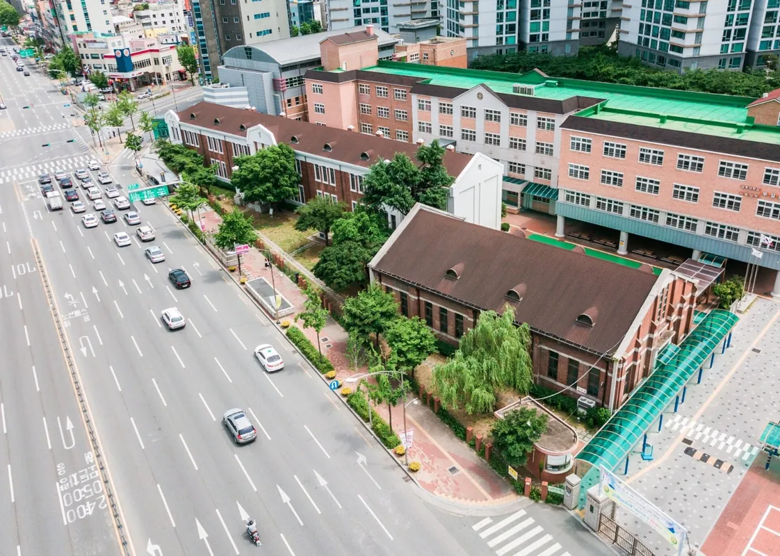 큰길가에 선 붉은 벽돌 학교 건물들을 위에서 내려다본 모습