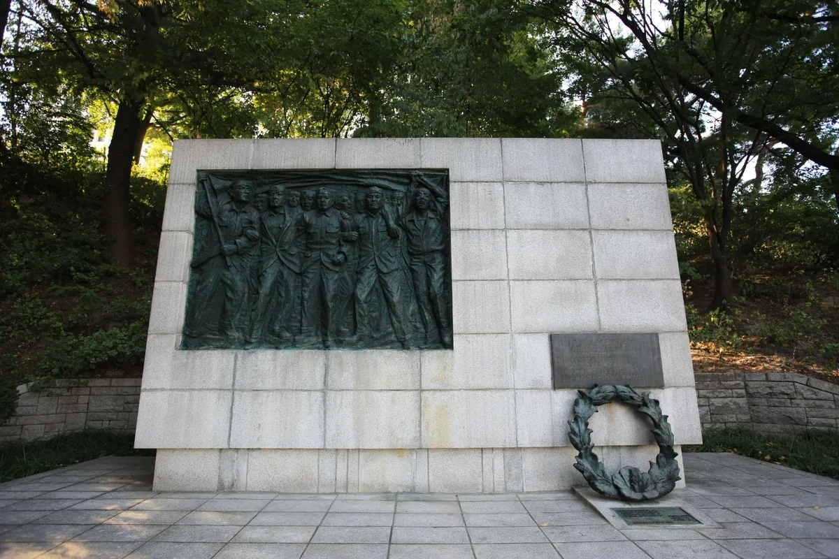 학생들의 모습을 새긴 부조와 그 앞에 놓인 화환
